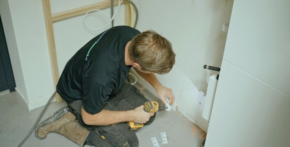 Een monteur van ThuisbatterijNederland.nl boort de muurbeugel voor de thuisbatterij vast