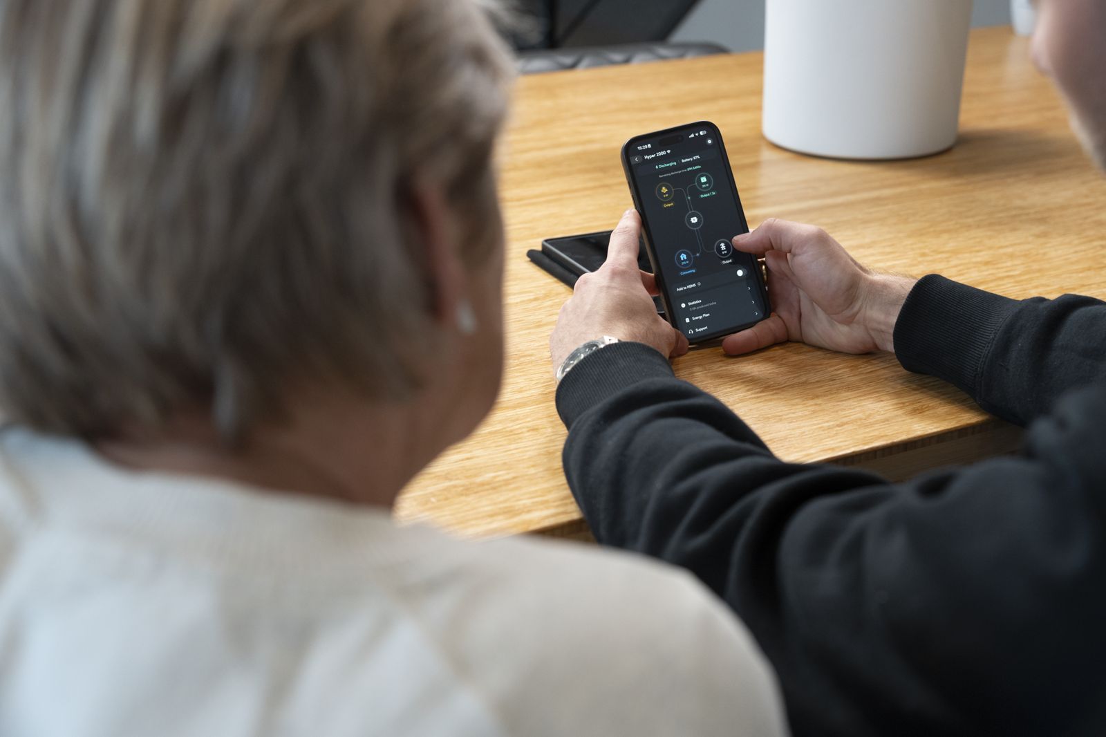De app van een thuisbatterij met live laad- en verbruiksgegevens op een telefoon